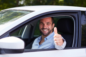 Man giving thumbs up as he parks his car