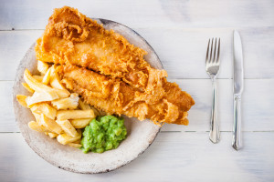 A plate of fish and chips with mushy peas